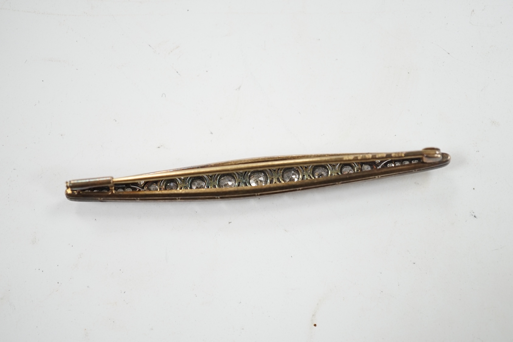 An Eastern European yellow metal (stamped 585) and white metal (stamped 875) and graduated diamond set bar brooch, 65mm, gross 5.1 grams. Condition - fair